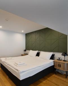 a bedroom with a large bed with a green headboard at Apartament Trzy Rysie "Laguna Beskidów" in Zarzecze