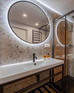 a bathroom with a sink and a mirror at Apartament Trzy Rysie "Laguna Beskidów" in Zarzecze