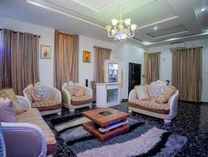 a living room with three couches and a table at Luxury 4 bedroom duplex in Lekki