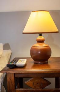 a lamp sitting on a table with a remote control at Marina's Rooms in Larnaca