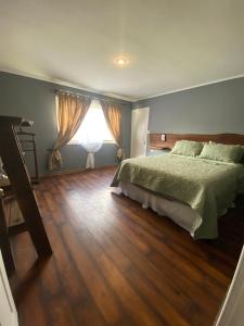 Un dormitorio con una cama grande y una ventana. en Lodge Dream Pucon, en Pucón