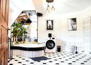 a bathroom with a black and white tile floor and a tub at ROMANTIC-Apartment - Altbauflair mit Dachterrasse & Waldblick, Maisonette, 80m2 in Annweiler am Trifels