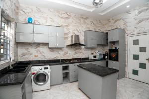a kitchen with white cabinets and a washer and dryer at Luxury 4 bedroom duplex in Lekki