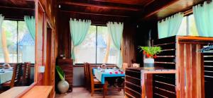 a dining room with a table and some windows at Mekong Bird Resort & Hotel in Stœ̆ng Trêng
