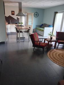 een keuken en een woonkamer met een tafel en stoelen bij B&B Typisch Lelies in Liessel