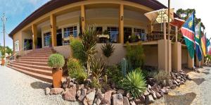 a building with a flag and plants in front of it at Bahnhof Hotel Aus in Aus