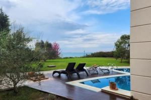 una piscina con 2 sillas y una mesa al lado en Lux villla near cntr with view pool beach accss, en Sarıyer