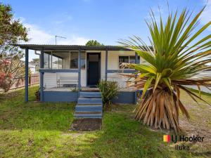 une maison avec un palmier devant dans l'établissement Fisherman's Cottage, à Iluka