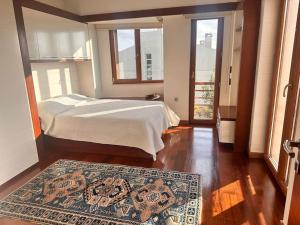 1 dormitorio con cama y alfombra en el suelo de madera en Lux villla near cntr with view pool beach accss, en Sarıyer