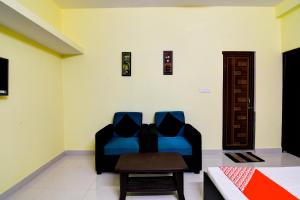 a living room with a blue couch and a table at OYO Flagship Sri Balaji Guest House in Bhubaneshwar