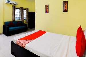 a bedroom with a bed and a couch at OYO Flagship Sri Balaji Guest House in Bhubaneshwar