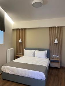 - une chambre avec un grand lit et des oreillers blancs dans l'établissement 11 Luxury Apartments.., à Metsovo