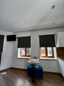 a room with two windows and a table and chairs at 11 Luxury apartments. in Metsovo