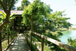 a walkway next to a river next to a building at Mekong Bird Resort & Hotel in Stœ̆ng Trêng +52 photos