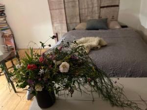 um cão deitado numa cama com um ramo de flores em Boutique Hotel Caramel em Jönköping