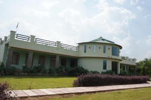 a large white building with a grass yard at GREEN VALLEY SARISKA in Tehla