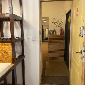 einen Flur mit einer Treppe, die in ein Zimmer führt in der Unterkunft Victoria Poshtel Bucharest in Bukarest