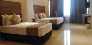 two beds in a hotel room with two beds at Eastland Hotel And Residences in Cebu City