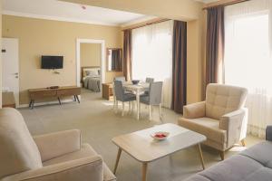 Kumru Suites في Sarıcaeli: غرفة معيشة مع أريكة وطاولة