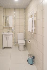 a white bathroom with a toilet and a sink at Kumru Suites in Sarıcaeli