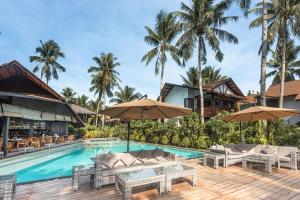 a pool at the resort with tables and umbrellas at Siargao Island Villas in General Luna