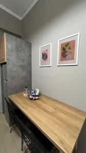 uma mesa de madeira numa cozinha com duas fotografias na parede em K&M 40 ekklision B’ em Drama