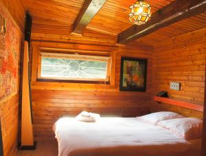 SapoisにあるParadis Sud Vosges Gérardmer Panorama Calmeの木造キャビン内のベッド1台が備わるベッドルーム1室を利用します。