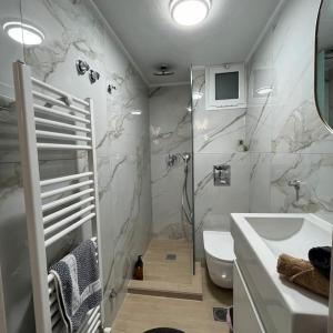 La salle de bains blanche est pourvue d'un lavabo et de toilettes. dans l'établissement K&M 40 ekklision B’, à Dráma