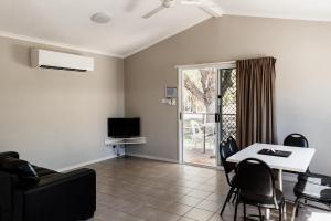 a living room with a table and chairs and a tv at BIG4 Breeze Holiday Parks - Katherine in Katherine