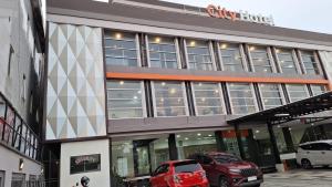 deux voitures garées sur un parking devant un immeuble dans l'établissement City Hotel Balikpapan, à Klandasan-besar