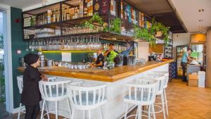 a woman standing at a bar in a restaurant at Luxury Four Seasons Life Sea Front Apartment 6-C in Boğaz