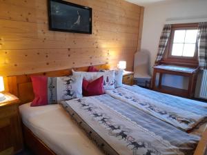 a bedroom with a large bed with a wooden wall at Ferienhaus Grofn in Matrei in Osttirol
