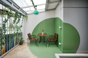 een groene kamer met een tafel en stoelen bij Summer house in Chiang Mai