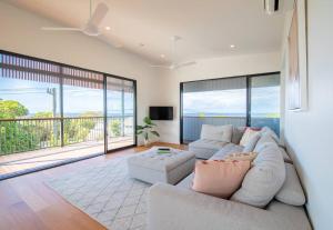 a living room with a couch and a large window at Float on Cylinder - Ocean Views - Plunge Pool in Point Lookout