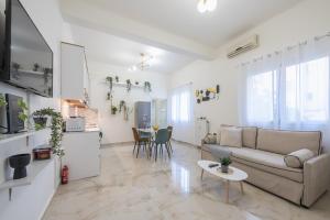 a living room with a couch and a table at MODERN APARTMENT 200M FROM ACROPOLIS 100Mbps NETFLIX in Athens