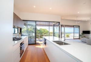 a kitchen with white countertops and a living room at Float on Cylinder - Ocean Views - Plunge Pool in Point Lookout