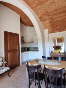 cocina y comedor con mesa y sillas en Fornace del Conte, en Abbadia di Montepulciano