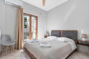 a white bedroom with a large bed and a desk at Vasilis Apartments Beachfront in Ermioni