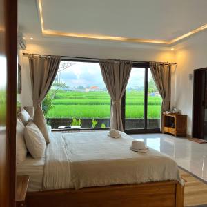 a bedroom with a large bed with a large window at Kubu Bali Baik Villa & Resort - CHSE Certified in Ubud