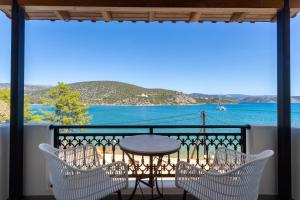 a table and chairs on a balcony with a view of the water at Vasilis Apartments Beachfront in Ermioni