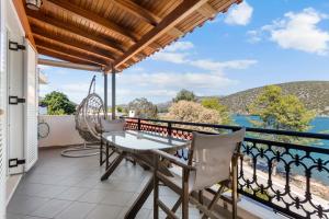 a balcony with a table and chairs and a view of the water at Vasilis Apartments Beachfront in Ermioni