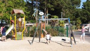 um grupo de crianças a brincar num parque infantil em Mobil-home a louer dans un camping **** proche de la mer et forêt em Saint-Jean-de-Monts