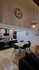 a kitchen with a table and chairs and a clock on the wall at Duplex Saint-Pierre - Parking et wifi gratuit in Chartres +34 photos