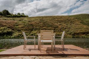 two chairs sitting on a dock next to a lake at Audley End Farm in Curryʼs Post