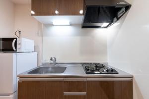 a kitchen with a sink and a microwave at Crest Court Kagurazaka in Tokyo