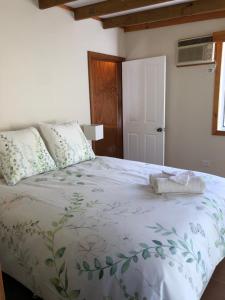 1 dormitorio con 1 cama con edredón verde y blanco en Copeland Cabins en Copeland