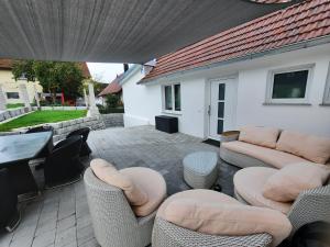 d'une terrasse avec des canapés, des chaises et une table. dans l'établissement Ferienwohnung Bauernhaus, à Balingen
