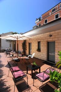grupa krzeseł i stołów z parasolami na patio w obiekcie Villa Santacroce w mieście San Giovanni Rotondo