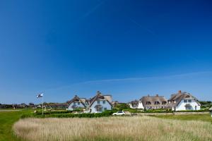 a group of houses in a field of grass at Strandvogtei Sylt in Rantum