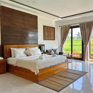 1 dormitorio con 1 cama grande y cabecero de madera en Kubu Bali Baik Villa & Resort - CHSE Certified, en Ubud